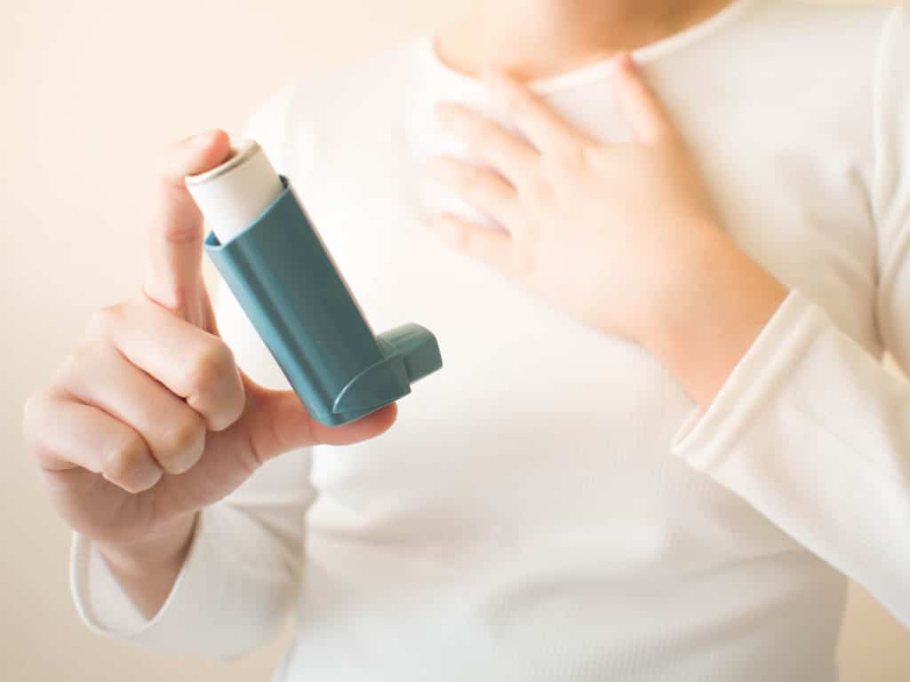 woman having breathing troubles holding inhaler